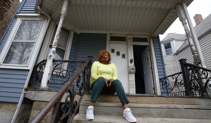 Dianne Green sits on the porch of her home in Chicago on Wednesday, March 24, 2021. The retiree, cancer survivor and mother worked for the city of Chicago in the water department and has lived in this home in Chicago's Austin neighborhood for years. (AP Photo/Martha Irvine)