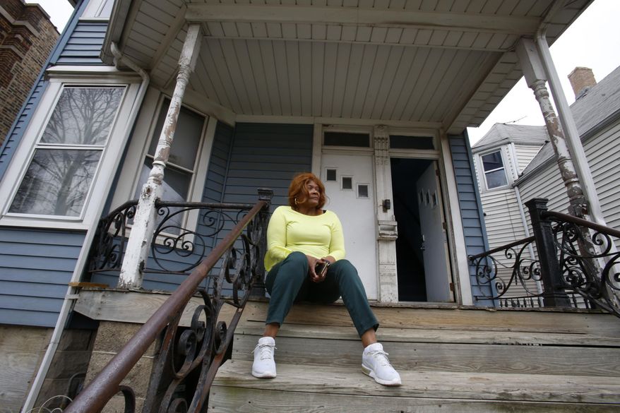 Dianne Green sits on the porch of her home in Chicago on Wednesday, March 24, 2021. The retiree, cancer survivor and mother worked for the city of Chicago in the water department and has lived in this home in Chicago's Austin neighborhood for years. (AP Photo/Martha Irvine)