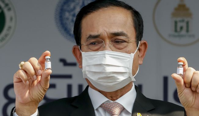 FILE - In this Feb. 24, 2021, file photo, Thai Prime Minister Prayuth Chan-ocha holds samples of Sinovac vaccine during a ceremony to mark the arrival of 200,000 doses of the Sinovac vaccine shipment at Suvarnabhumi airport in Bangkok, Thailand. Prayuth was not particularly lauded for his leadership last year against the coronavirus, but for much of 2020 Thailand fought the disease to a standstill, with low infection and death rates envied by more developed countries. (AP Photo/Sakchai Lalit, File)