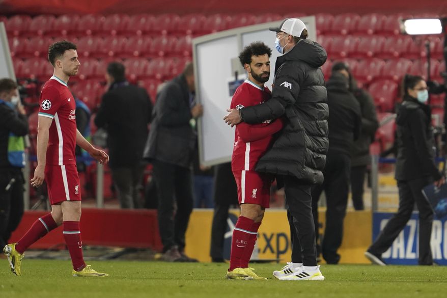 Liverpool&#39;s manager Jurgen Klopp, right, greets Liverpool&#39;s Mohamed Salah at the end of the Champions League quarter final second leg soccer match between Liverpool and Real Madrid at Anfield stadium in Liverpool, England, Wednesday, April 14, 2021. (AP Photo/Jon Super)