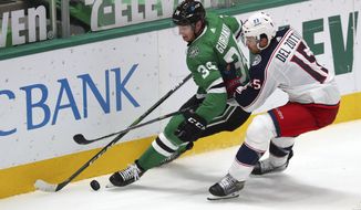 Dallas Stars right wing Denis Gurianov (34) and Columbus Blue Jackets defenseman Michael Del Zotto (15) battle for the puck int he second period during an NHL hockey game on Thursday, April 15, 2021, in Dallas. (AP Photo/Richard W. Rodriguez)