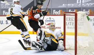 Pittsburgh Penguins goaltender Tristan Jarry makes a save on a shot by Philadelphia Flyers&#39; Travis Konecny (11) with Penguins&#39; Brian Dumoulin (8) defending during the second period of an NHL hockey game in Pittsburgh, Thursday, April 15, 2021. (AP Photo/Gene J. Puskar)