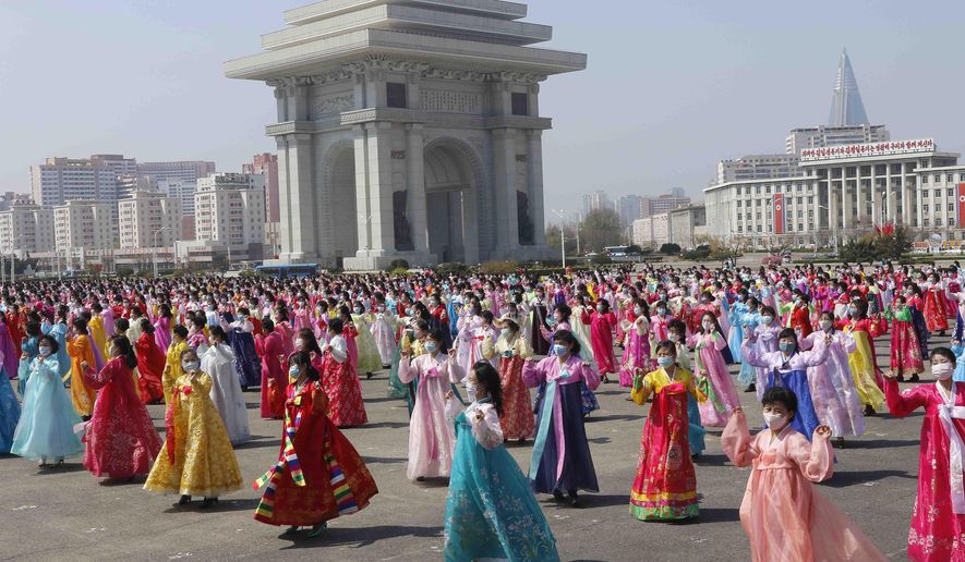 Women dance near the Arch of Triumph on the Day of the Sun, the birth anniversary of late leader Kim Il Sung, in Pyongyang, North Korea Thursday, April 15, 2021. (AP Photo/Jon Chol Jin)