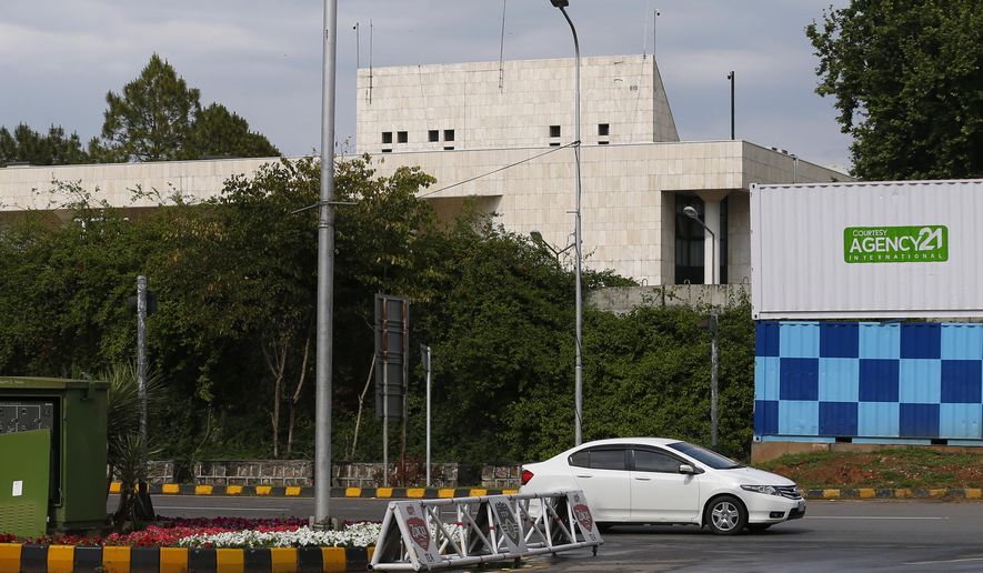 A car drives past the French Embassy, in Islamabad, Pakistan, Thursday, April 15, 2021. The French embassy in Pakistan on Thursday advised all of its nationals and companies to temporarily leave the country after anti-France violence erupted in the Islamic nation over the arrest of a radical leader. Saad Rizvi was arrested Monday for threatening the government with mass protests if it did not expel French envoy Marc Baréty over the publication depictions of Islam’s Prophet Muhammad. (AP Photo/Anjum Naveed)