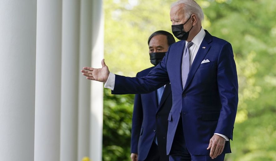 President Joe Biden, accompanied by Japanese Prime Minister Yoshihide Suga, walks from the Oval Office to speak at a news conference in the Rose Garden of the White House, Friday, April 16, 2021, in Washington. (AP Photo/Andrew Harnik)
