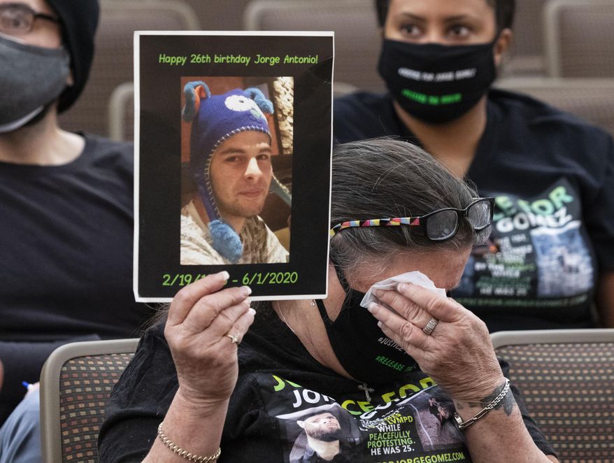 Carol Luke, holding a photograph of Jorge Gomez, weeps as she attends a public fact-finding review for the fatal officer involved shooting of Gomez at the Clark County Government Center, on Friday, April 16, 2021, in Las Vegas. (Bizuayehu Tesfaye/Las Vegas Review-Journal via AP)