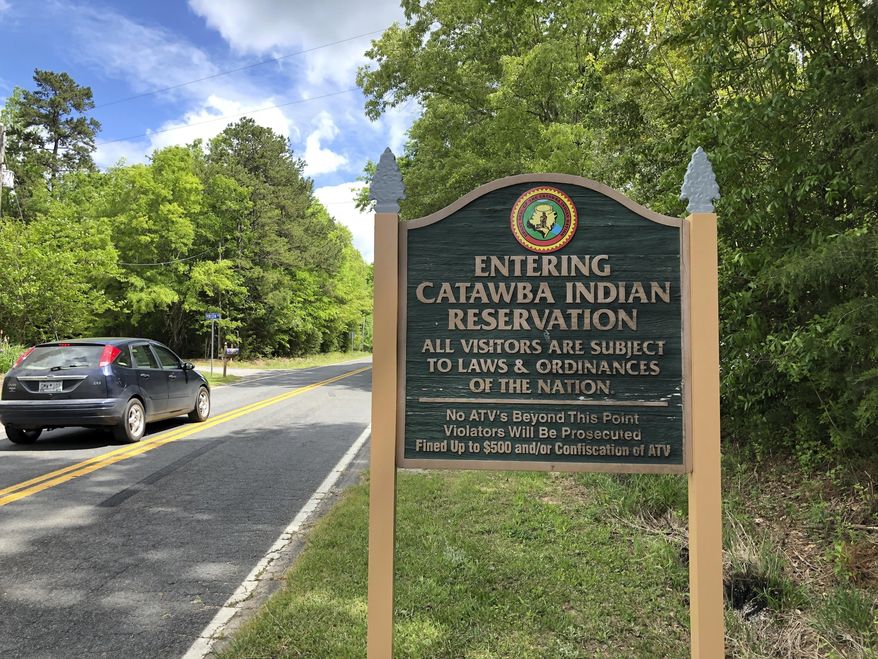 FILE - In this Friday, April 26, 2019 file photo, a sign welcomes people to the Catawba Indian Nation’s reservation near Rock Hill, S.C. The South Carolina-based tribe has received federal and state approvals to build and run a casino near Kings Mountain, North Carolina. A federal judge on Friday rejected a legal challenge from Eastern Band of Cherokee Indians, which currently runs two casinos in the state. The land for the proposed casino is 35 miles (56 kilometers) northwest of the Catawba reservation in upstate South Carolina. (AP Photo /Jeffrey Collins, File)