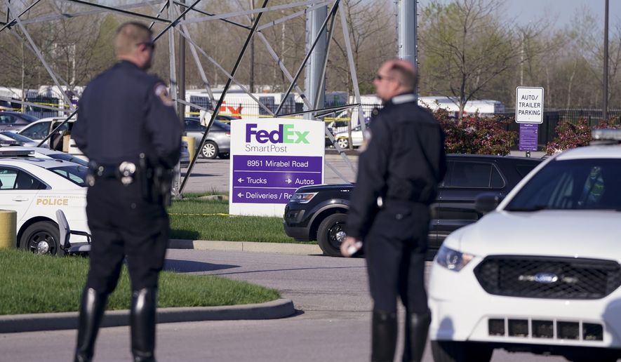 Police stand near the scene where multiple people were shot at the FedEx Ground facility early Friday morning, April 16, 2021, in Indianapolis. A gunman killed eight people and wounded several others before apparently taking his own life in a late-night attack at a FedEx facility near the Indianapolis airport, police said, in the latest in a spate of mass shootings in the United States after a relative lull during the pandemic. (AP Photo/Michael Conroy)