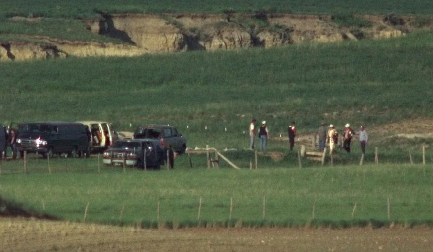 FILE - In this June 13, 1996, file photo, members of the Freemen group surrender to FBI agents at the negotiation site on the Freeman compound outside Jordan, Mont. A member of the anti-government Montana Freemen who took part in the extremist group's 81-day armed standoff with FBI agents has died in prison. Federal officials say Russell Dean Landers, 69, died Saturday, April 10, 2021, while in custody at the Federal Correctional Institution at Terre Haute, Ind. (AP Photo/Michael S. Green, File)