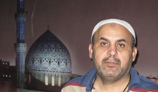 This 2003 photo shows Khodeir Majid at the AP office at the Palestine hotel.  Majid, who covered Iraq’s numerous conflicts as a video producer and cameraman for the Associated Press over 17 years has died at the age of 64. Relatives said the cause of his death on Friday morning was complications due to the coronavirus.  (AP Photo/Ahmad Sami