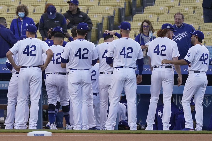 The Los Angeles Dodgers enter the dugout before their baseball game against the Colorado Rockies Thursday, April 15, 2021, in Los Angeles. All players wore jersey number 42 to honor Jackie Robinson, the first African American to play in Major League Baseball. (AP Photo/Ashley Landis) **FILE**