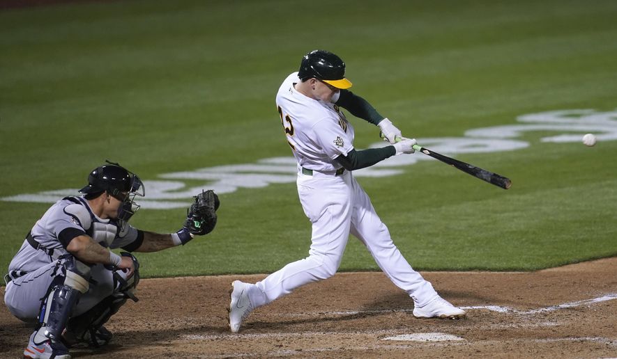Oakland Athletics&#39; Matt Chapman hits a two-run double in front of Detroit Tigers catcher Wilson Ramos during the sixth inning of a baseball game in Oakland, Calif., Thursday, April 15, 2021. (AP Photo/Jeff Chiu)