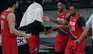 Portland Trail Blazers forward Norman Powell (24) and guard CJ McCollum, second from right, celebrate their win against the San Antonio Spurs with teammates Enes Kanter (11) and Carmelo Anthony, second from left, during the second half of an NBA basketball game in San Antonio, Friday, April 16, 2021. (AP Photo/Eric Gay)