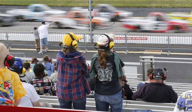 Fans watch the trucks pass on the front stretch during the NASCAR Truck Series auto race Saturday, April 17, 2021, at Richmond Raceway in Richmond, Va. (James H Wallace/Richmond Times-Dispatch via AP)