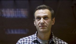 In this Saturday, Feb. 20, 2021, file photo, Russian opposition leader Alexei Navalny stands in a cage in the Babuskinsky District Court in Moscow, Russia. A doctor for the imprisoned Russian opposition leader, who is in the third week of a hunger strike, said on Saturday April 17, 2021, that his health is deteriorating rapidly and the 44-year-old Kremlin critic could be on the verge of death. (AP Photo/Alexander Zemlianichenko, File)