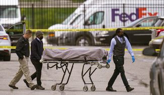 A body is taken from the scene where multiple people were shot at a FedEx Ground facility in Indianapolis, Friday, April 16, 2021. A gunman killed several people and wounded others before taking his own life in a late-night attack at a FedEx facility near the Indianapolis airport, police said.  (AP Photo/Michael Conroy)