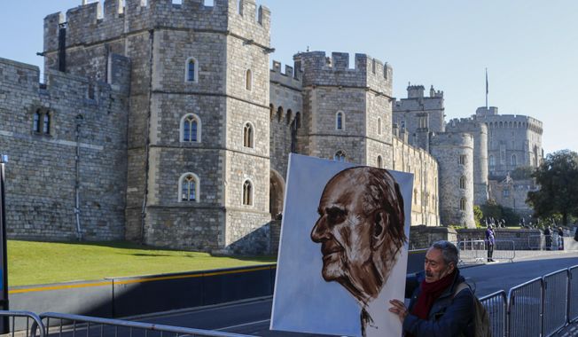 Artist Kaya Mar holds a portrait of Prince Philip ahead of the Prince&#x27;s funeral in Windsor, England Saturday April 17, 2021. Philip died April 9 at the age of 99 after 73 years of marriage to Britain&#x27;s Queen Elizabeth II. Coronavirus restrictions mean there will be only 30 mourners for the service, including the widowed queen, her four children and her eight grandchildren. (AP Photo/Frank Augstein)