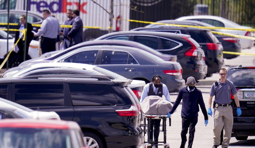A body is taken from the scene where multiple people were shot at a FedEx Ground facility in Indianapolis, Friday, April 16, 2021. A gunman killed several people and wounded others before taking his own life in a late-night attack at a FedEx facility near the Indianapolis airport, police said. (AP Photo/Michael Conroy)