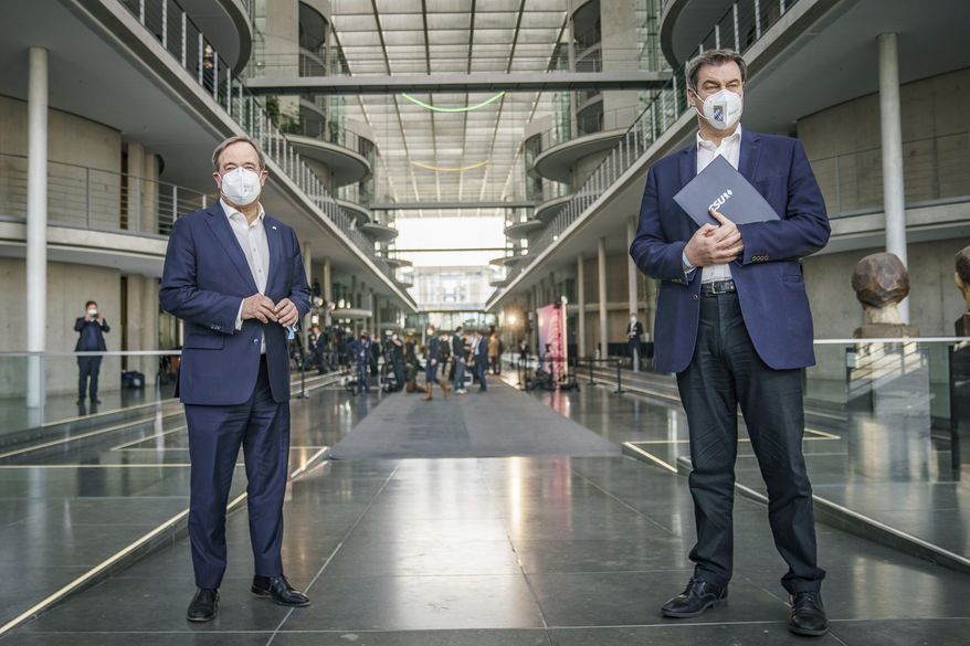 FILE-In this April 11, 2021 taken photo Markus Soeder, right, State Governor of Bavaria and CSU party leader, stands next to Armin Laschet, CDU federal leader and State Governor of North Rhine-Westphalia, after a press conference at the German parliament Bundestag in Berlin, Germany. Pressure mounted Saturday on the two contenders to lead Chancellor Angela Merkel's center-right bloc into September's German election to agree on which of them will run to succeed her and end their power struggle. (Michael Kappeler/dpa via AP)