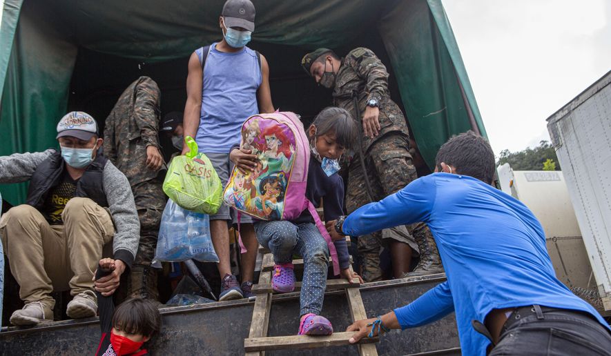 In this Jan. 19, 2021, file photo, a Honduran migrant child is helped off an Army truck after being returned to El Florido, Guatemala, one of the border points between Guatemala and Honduras. The reasons Hondurans continue to flee their country have been well documented: pervasive violence, deep-seated corruption, lack of jobs and widespread destruction from two major hurricanes that struck the region last November. (AP Photo/Oliver de Ros, File)