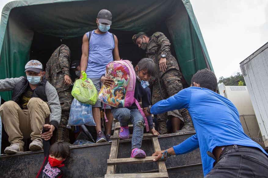 In this Jan. 19, 2021, file photo, a Honduran migrant child is helped off an Army truck after being returned to El Florido, Guatemala, one of the border points between Guatemala and Honduras. The reasons Hondurans continue to flee their country have been well documented: pervasive violence, deep-seated corruption, lack of jobs and widespread destruction from two major hurricanes that struck the region last November. (AP Photo/Oliver de Ros, File)