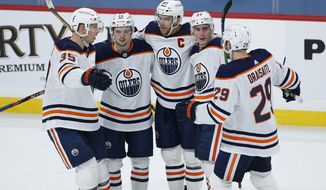 Edmonton Oilers&#39; Alex Chiasson (39), Kailer Yamamoto (56), Connor McDavid (97), Tyson Barrie (22) and Leon Draisaitl (29) celebrate Barrie&#39;s goal against the Winnipeg Jets during the second period of an NHL hockey game Saturday, April 17, 2021, in Winnipeg, Manitoba. (John Woods/The Canadian Press via AP)
