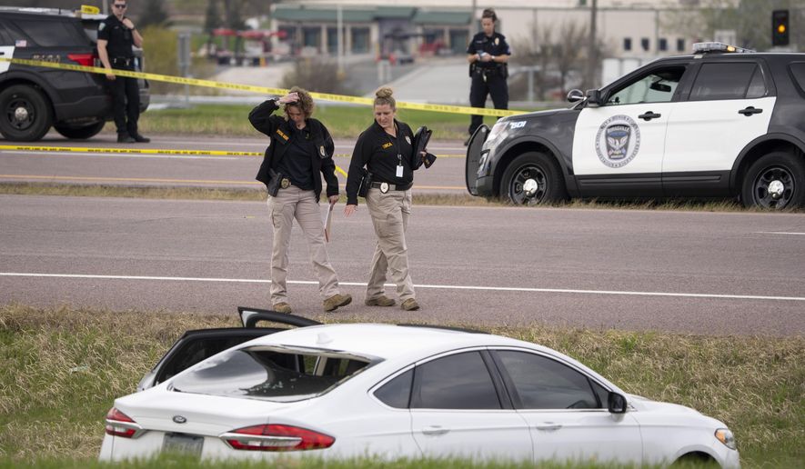 Two Bureau of Criminal Apprehension agents begin investigating the scene of an officer-involved shooting, Sunday, April 18, 2021, in Burnsville, Minn. A snippet of the traffic camera video posted online showed a man stepping out of a slowly moving vehicle on a highway on-ramp, then stepping into traffic and appearing to try to stop the SUV, which slowed and then veered away. A police car quickly pulled up next to the man. (Jeff Wheeler/Star Tribune via AP)