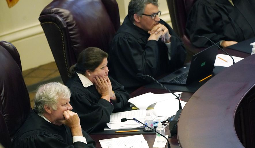 Mississippi Supreme Court Associate Justices T. Kenneth Griffis, left, Dawn Beam, center and Josiah Dennis Coleman, listen to attorneys presenting arguments over a lawsuit that challenges the state's initiative process and seeks to overturn a medical marijuana initiative that voters approved in November 2020, Wednesday, April 14, 2021, in Jackson, Miss. (AP Photo/Rogelio V. Solis)
