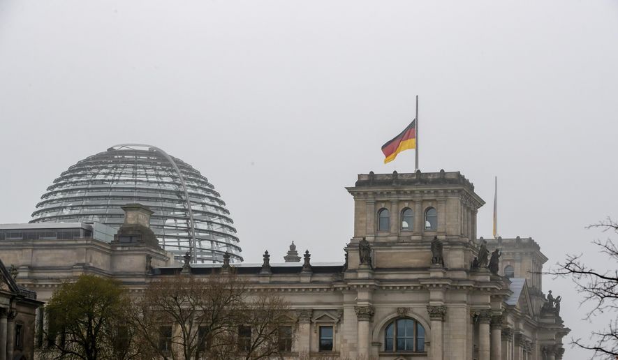 The German flag on top of the Reichstag building is seen at half-mast on the occasion of the central memorial for those who died in the Corona pandemic in Germany, Berlin, April 18, 2021. (Christoph Soeder/dpa via AP)