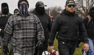 In this Jan. 6, 2021, file photo, Proud Boys members Joseph Biggs, left, and Ethan Nordean, right with megaphone, walk toward the U.S. Capitol in Washington. (AP Photo/Carolyn Kaster, File)