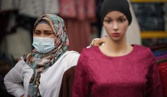 A Muslim vendor wearing protective mask waiting for customers at a Ramadan bazaar, amid the outbreak of the coronavirus disease (COVID-19) in Kuala Lumpur, Malaysia, Monday, April 19, 2021. (AP Photo/Vincent Thian)