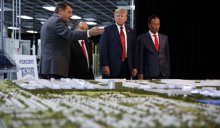 FILE - In this June 28, 2018 photo, President Donald Trump takes a tour of Foxconn with Foxconn chairman Terry Gou, right, and CEO of SoftBank Masayoshi Son in Mt. Pleasant, Wis. Foxconn Technology Group, the world&#x27;s largest electronics manufacturer, has reached a new deal with reduced tax breaks for its scaled back project in southeast Wisconsin, Gov. Tony Evers and the the company announced on Monday, April 19, 2021. (AP Photo/Evan Vucci, File)