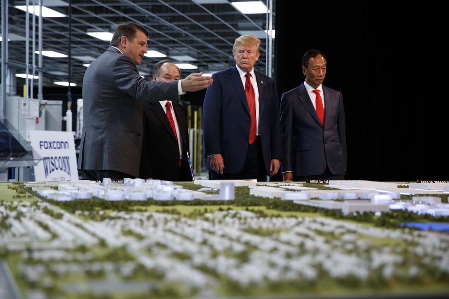 FILE - In this June 28, 2018 photo, President Donald Trump takes a tour of Foxconn with Foxconn chairman Terry Gou, right, and CEO of SoftBank Masayoshi Son in Mt. Pleasant, Wis. Foxconn Technology Group, the world&#39;s largest electronics manufacturer, has reached a new deal with reduced tax breaks for its scaled back project in southeast Wisconsin, Gov. Tony Evers and the the company announced on Monday, April 19, 2021. (AP Photo/Evan Vucci, File)