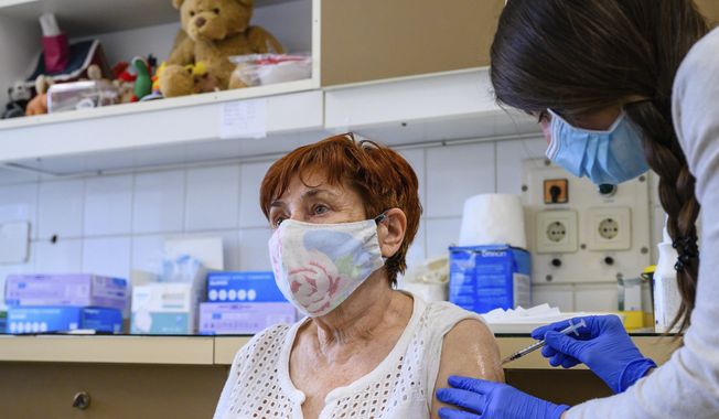 A health worker administers a dose of Pfizer-BioNtech vaccine against the new coronavirus to a patient at Szent Gyorgy Training Hospital in Szekesfehervar, Hungary, Monday, April 19, 2021. (Tamas Vasvari/MTI via AP)
