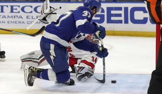 Tampa Bay Lightning&#39;s Yanni Gourde (37) scores the winning goal past Carolina Hurricanes goaltender Petr Mrazek, of the Czech Republic, during the overtime period of an NHL hockey game Monday, April 19, 2021, in Tampa, Fla. (AP Photo/Mike Carlson)