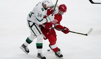 Dallas Stars&#39; Jamie Benn (14) and Detroit Red Wings center Dylan Larkin (71) compete for control of the puck in the first period of an NHL hockey game in Dallas, Monday, April 19, 2021. (AP Photo/Tony Gutierrez)