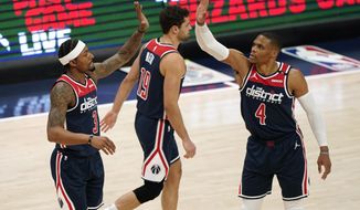 Washington Wizards guard Bradley Beal, left, high-fives teammate Russell Westbrook after Beal was fouled in the first half of an NBA basketball game, Monday, April 19, 2021, in Washington. (AP Photo/Patrick Semansky)