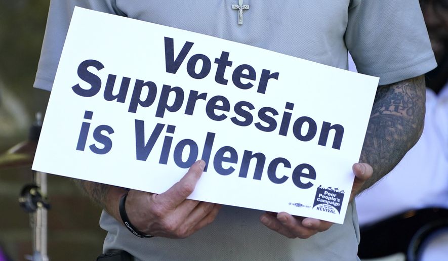 Benny Ivey, a former felon, holds a sign addressing voter suppression during a Poor People's Campaign assembly in downtown Jackson, Miss., Monday, April 19, 2021. Ivey was among speakers who called for an initiative to try simplify the way Mississippi restores voting rights to people convicted of some felonies, and other social issues. The Campaign seeks to have the issues addressed at a national assembly later this year. (AP Photo/Rogelio V. Solis)