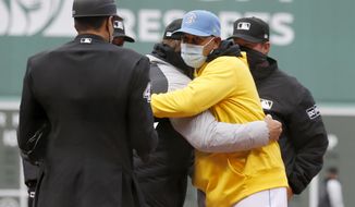 Boston Red Sox manager Alex Cora, front right, hugs Chicago White Sox manager Tony La Russa as the exchange lineups before a baseball game, Saturday, April 17, 2021, in Boston. (AP Photo/Mary Schwalm)