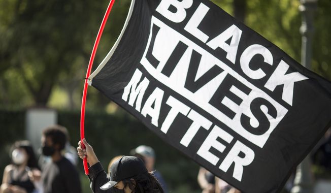 A man holding a &quot;Black Lives Matter&quot; flag outside of Los Angeles Mayor Garcetti&#x27;s house after a guilty verdict was announced at the trial of former Minneapolis police Officer Derek Chauvin for the 2020 death of George Floyd, Tuesday, April 20, 2021, in Los Angeles. Former Minneapolis police Officer Derek Chauvin has been convicted of murder and manslaughter in the death of Floyd. (AP Photo/Ringo H.W. Chiu)