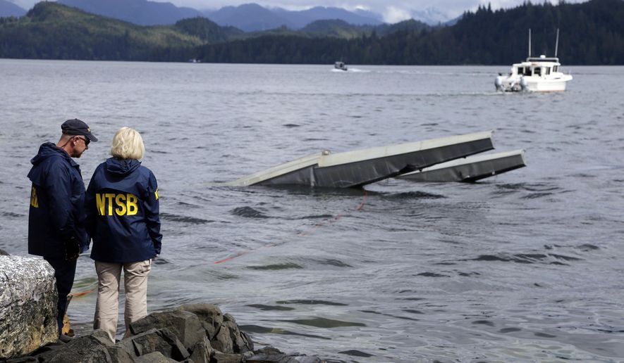 FILE - In this photo provided by the National Transportation Safety Board, NTSB investigator Clint Crookshanks, left, and member Jennifer Homendy stand near the site of some of the wreckage of the DHC-2 Beaver, Wednesday, May 15, 2019, that was involved in a midair collision near Ketchikan, Alaska, a couple of days earlier.  The pilots of two Alaskan sightseeing planes that collided in midair couldn&#39;t see the other aircraft because airplane structures or a passenger blocked their views, and they didn&#39;t get electronic alerts about close aircraft because safety systems weren&#39;t working properly. That&#39;s what the staff of the National Transportation Safety board found in their investigation. (Peter Knudson/NTSB via AP)