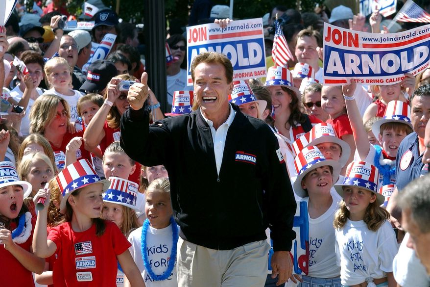 FILE - In this Oct. 5, 2003, file photo, then-Republican candidate for California governor Arnold Schwarzenegger walks up the steps to the state Capitol surrounded by children and waving to supporters during a campaign rally in Sacramento, Calif. No candidate of Schwarzenegger&#39;s fame has yet emerged in the expected 2021 recall election against Democratic Gov. Gavin Newsom. (AP Photo/Steve Yeater, File)