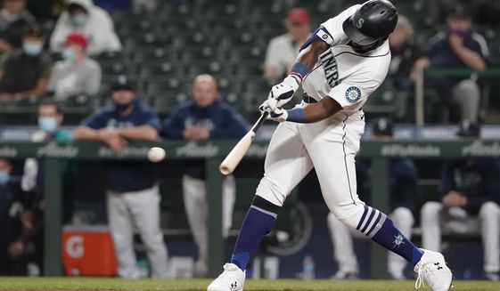 Seattle Mariners&#39; Taylor Trammell hits an RBI-double to score Luis Torrens during the fourth inning of a baseball game against the Los Angeles Dodgers, Monday, April 19, 2021, in Seattle. (AP Photo/Ted S. Warren)