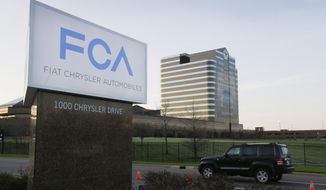 FILE - In this May 6, 2014, file photo, a vehicle moves past a sign outside Fiat Chrysler Automobiles world headquarters in Auburn Hills, Mich. Two Italian managers in Fiat Chrysler&#39;s diesel engine program have been indicted by a federal grand jury in Detroit in a widening case alleging a scheme to cheat on U.S. emissions tests. The indictments unsealed Tuesday, April 20, 2021, detail allegations of a plot to dupe the Environmental Protection Agency by rigging more than 100,000 diesel Ram pickup trucks and Jeep SUVs to cheat on EPA tests and exceed pollution limits on real roads. (AP Photo/Carlos Osorio, File)