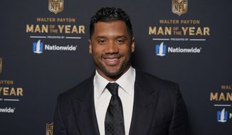 FILE - In this Friday, Feb. 5, 2021 file photo Seattle Seahawks quarterback Russell Wilson poses for a photo at the NFL Honors ceremony as part of Super Bowl 55  in Tampa, Fla. Wilson will return to N.C. State University, where he played football and baseball, this spring as a commencement speaker for the 2021 graduation ceremonies.  (AP Photo/Charlie Riedel, File)