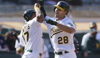 Oakland Athletics&#39; Matt Olson (28) is congratulated by Elvis Andrus after hitting a grand slam home run against the Minnesota Twins during the fourth inning of the first baseball game of a doubleheader in Oakland, Calif., Tuesday, April 20, 2021. (AP Photo/Jeff Chiu)