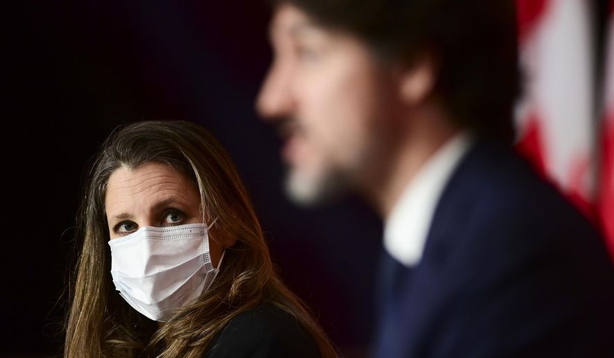 Canadian Finance Chrystia Freeland looks towards Prime Minister Justin Trudeau as they hold a press conference in Ottawa, Ontario, Tuesday, April 20, 2021. (Sean Kilpatrick/The Canadian Press via AP)