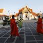 Buddhist monks wear face masks to protect themselves from the coronavirus during a morning alms offerings at Marble Temple in Bangkok, Thailand Friday, April 16, 2021. (AP Photo/Sakchai Lalit)