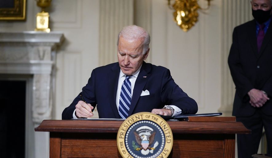 In this Jan. 27, 2021 file photo, President Joe Biden signs an executive order on climate change, in the State Dining Room of the White House in Washington. (AP Photo/Evan Vucci) ** FILE **