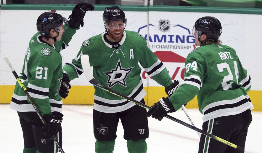 Dallas Stars&#39; Jason Robertson (21) and Roope Hintz (24) celebrate a third-period goal by Joe Pavelski (16) against the Columbus Blue Jackets during an NHL hockey game Thursday, April 15, 2021, in Dallas. (AP Photo/Richard W. Rodriguez)